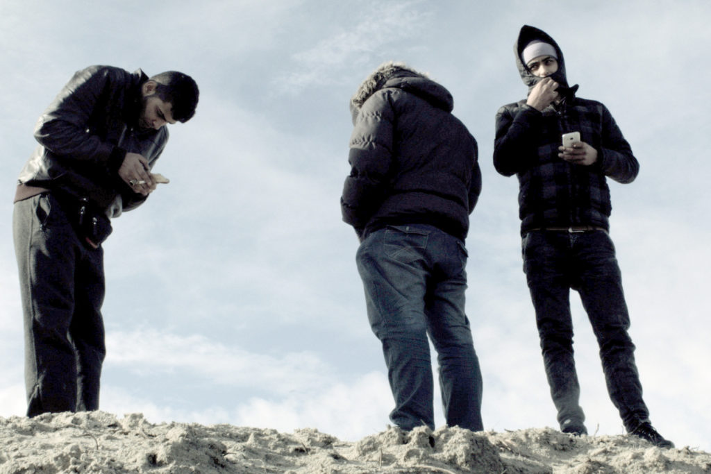 Gruppe von drei Männern steht auf einem Fels. Filmstill aus "Wohin, Flüchtling?" © Shellac