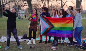 Queere Menschen mit Regenbogenflagge