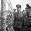 Bild von Heinrich Himmler and einem Zaun stehend gegenüber einem Gefangenen in schwarz/weiß
