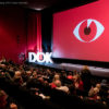 Bild eines Kinosaals mit Publikum und dem DOK Fest Logo