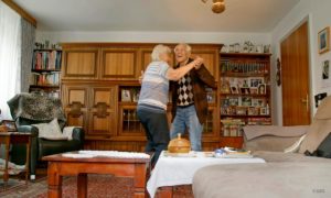 Szene aus der Kurzdoku "Alexa bitte einen Walzer spielen": Bild eines alten Paars, das in einem Wohnzimmer tanzt