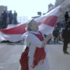 Filmstill aus „Courage“ von Aliaksei Paluyan; man sieht eine demonstrierende Frau mit Fahne (Foto: Living Pictures Production)