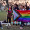 Queere Menschen mit Regenbogenflagge